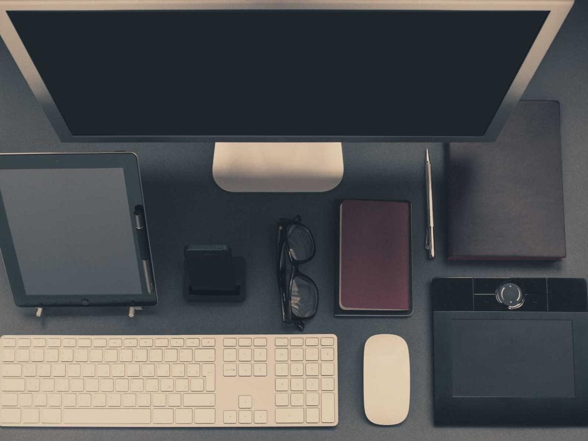 Scrivania ordinata con monitor, tastiera e tablet
